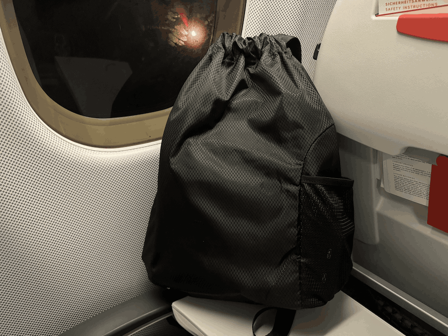 A NOA device in a travel string bag at an airplane seat.