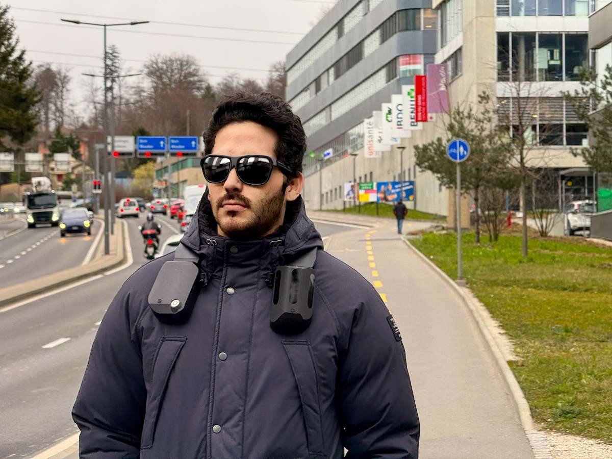 A person walking down a street with a NOA device on the shoulders.